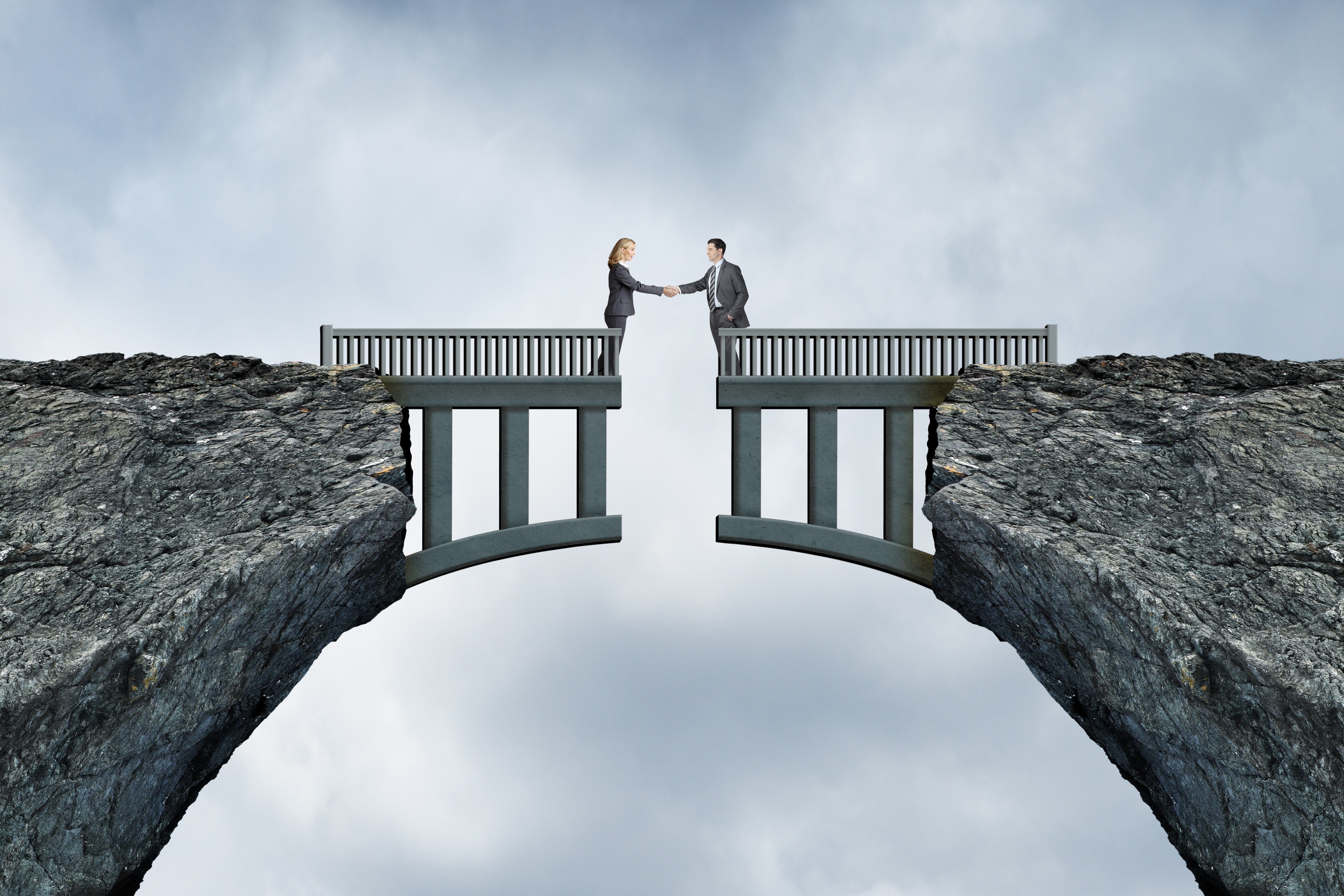 Photo of two business people meeting across a bridge